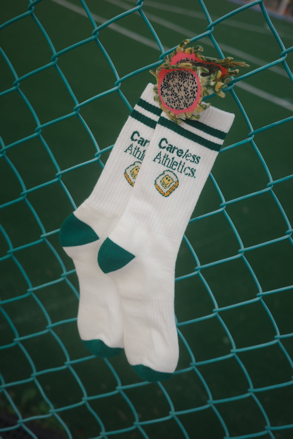 White socks with green accents and text on a green mesh background