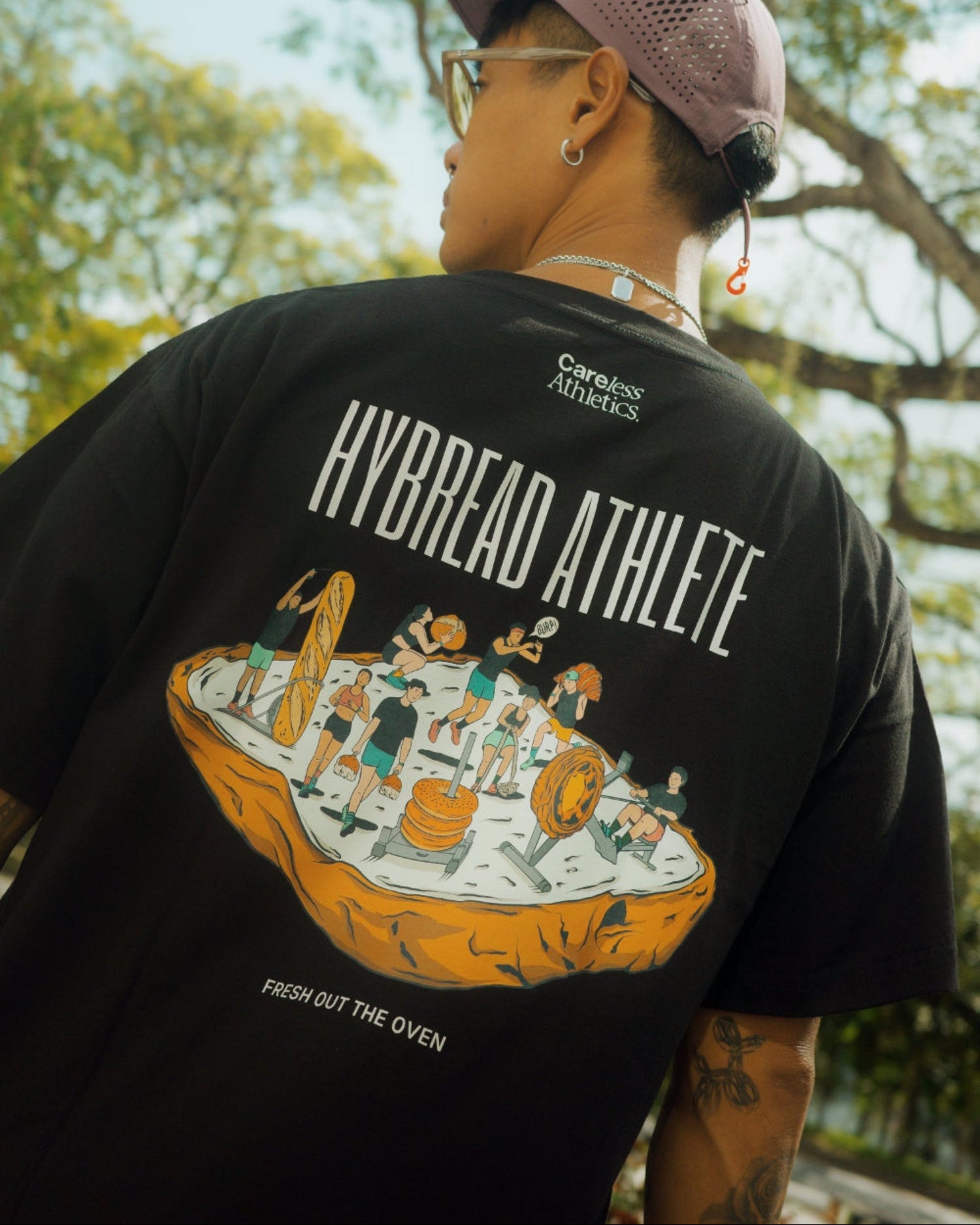 Person wearing a black 'Hybrid Athlete' t-shirt with a graphic design outdoors.