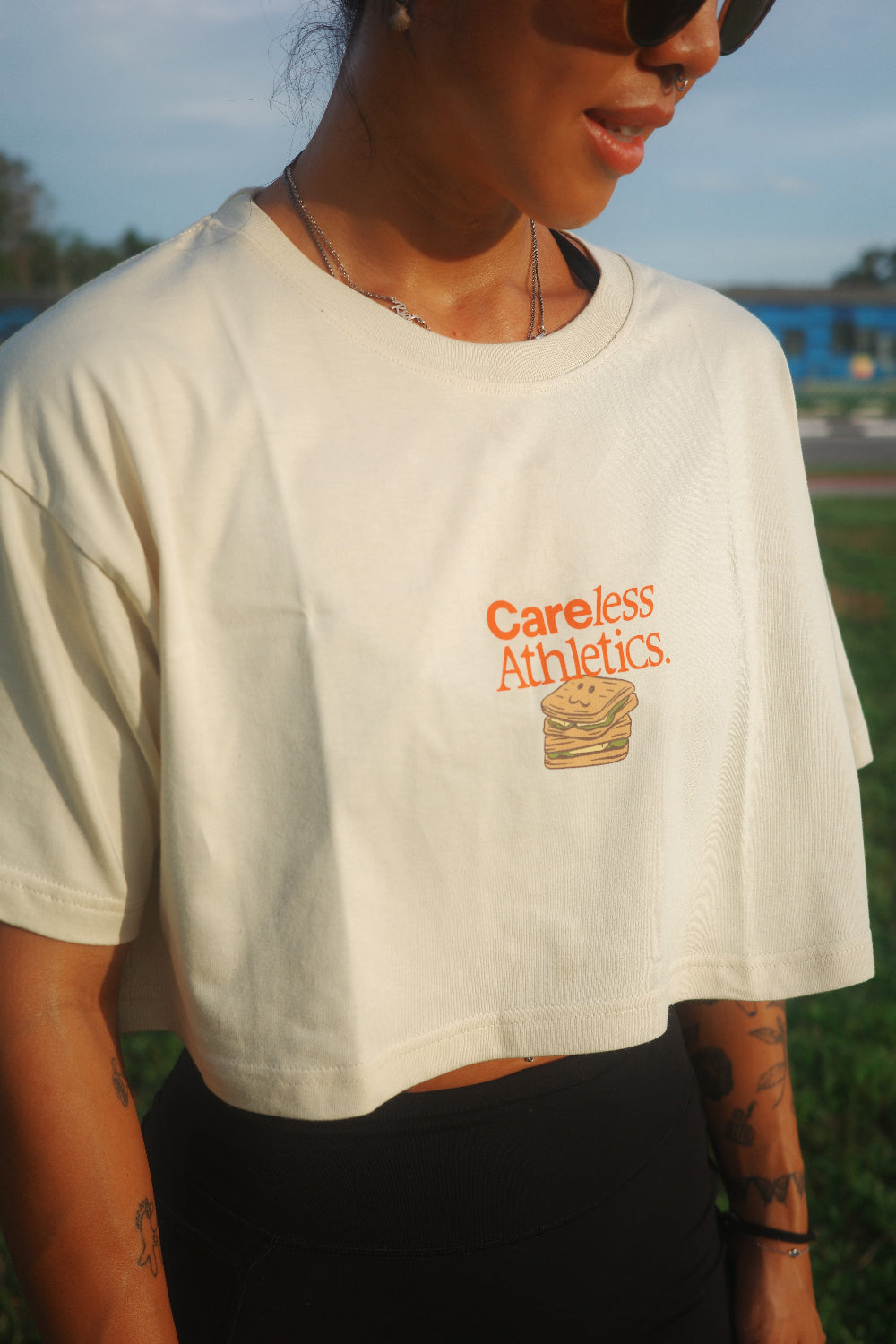 Person wearing a white t-shirt with 'Careless Athletics' logo outdoors
